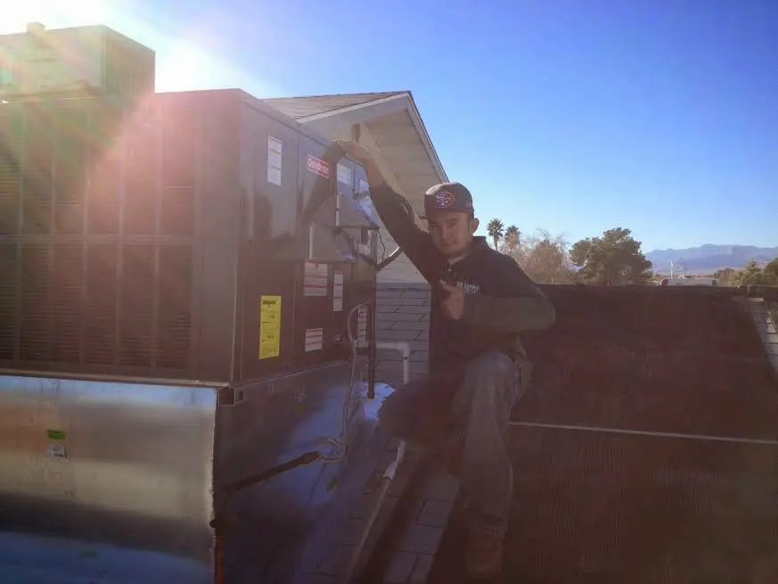 HVAC technician performing HVAC Inspection on a rooftop unit in Allegan
